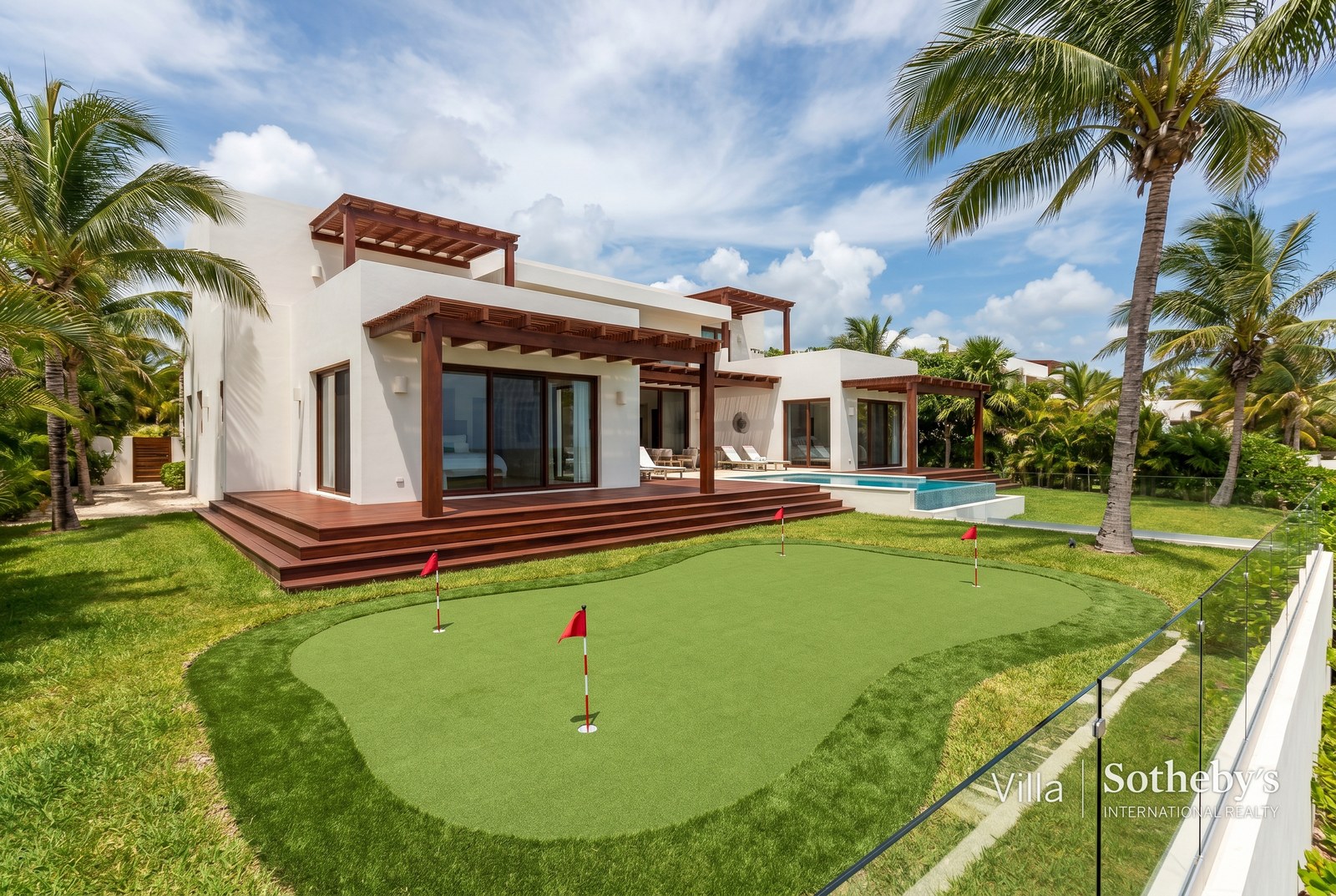 Putting green premium integrado a jardín tropical de residencia en Riviera Maya con palmas y vegetación caribe